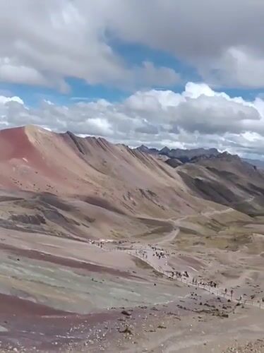 Tourists document Rainbow Mountain's colorful landscape in Peru