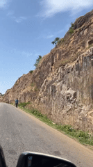 Rocky cliff face documented along paved road in Nigeria