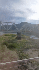 Train passenger observes bridge over river near Mostovoi, Russia