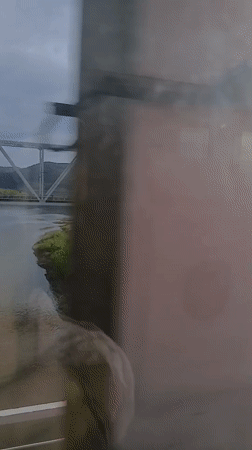 Train passenger observes bridge over river near Mostovoi, Russia