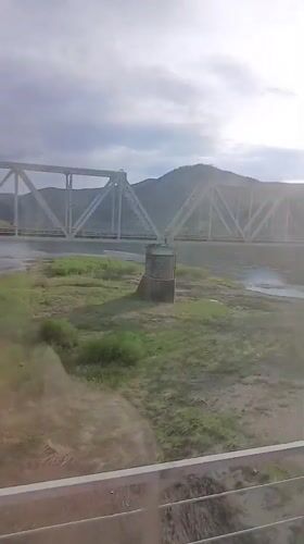 Train passenger observes bridge over river near Mostovoi, Russia