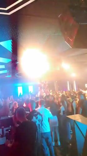 Crowded nightclub scene with performer and light effects in Nesebar