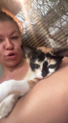 Woman holds calm calico kitten indoors in North Kuta