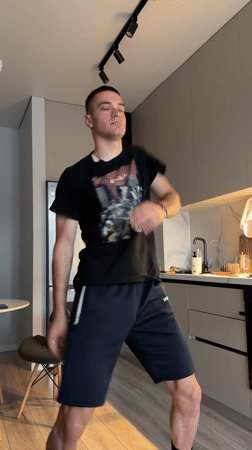 Young man dances casually in Bishkek kitchen late evening