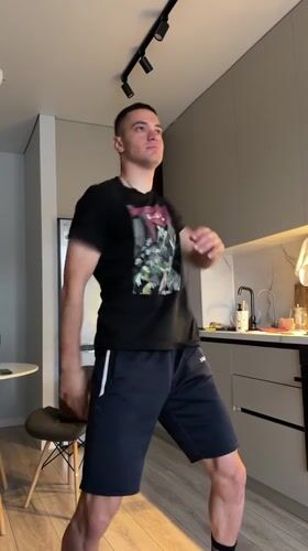 Young man dances casually in Bishkek kitchen late evening