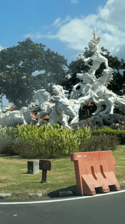 Driver eating with spoon near horse statue in Kuta