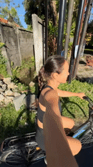 Woman with bicycle stops on roadside in Singakerta, Indonesia