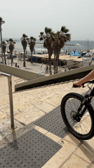 Cyclist rides bicycle down stone steps in Tel Aviv