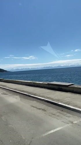 Vehicle travels waterfront road in Listvyanka, Russia