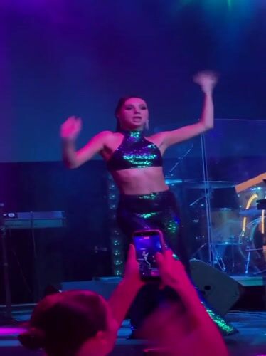 Live stage performance in Georgia, green outfit, DJ and drums