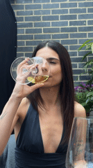 Woman drinks white wine in London evening scene