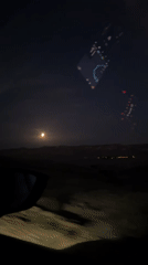 Nighttime driving footage captures full moon over Arad roadway