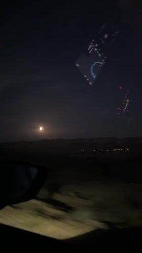 Nighttime driving footage captures full moon over Arad roadway