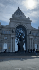 Tourists photograph Palace of Farmers tree sculpture in Kazan