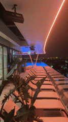 Neon-lit rooftop pool and modern hotel exterior in Cascais