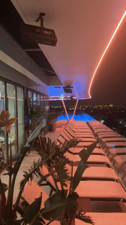 Neon-lit rooftop pool and modern hotel exterior in Cascais