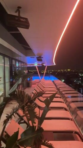 Neon-lit rooftop pool and modern hotel exterior in Cascais