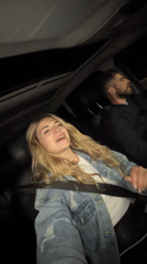 Woman sings in passenger seat during car ride in Montenegro