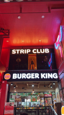 Street musician performs amid Patong nightlife district activity