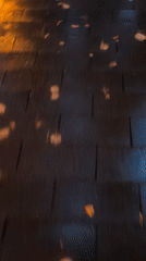 Rain-slicked park path glowing under autumn evening lamplight