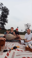 Six people gather on blanket at Arambol beach