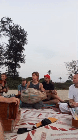 Six people gather on blanket at Arambol beach