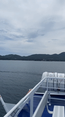 Ferry with Thai flag cruises waters near Baan Sri Thanu