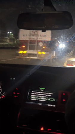 Driver passes wide-load truck on Nigerian highway at night