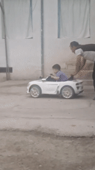 Child enjoys toy car ride in Khujand courtyard