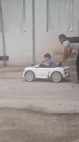 Child enjoys toy car ride in Khujand courtyard