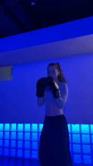 Woman trains boxing in blue-lit Moscow room