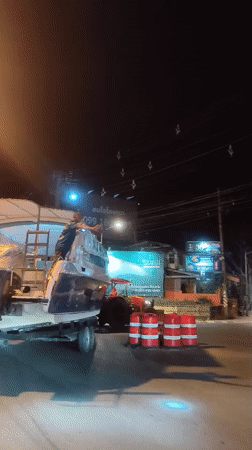 Boat transported on trailer through Thai village streets