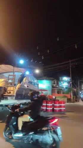 Boat transported on trailer through Thai village streets