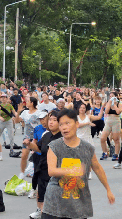 Park aerobics class shares space with a hunting monitor lizard