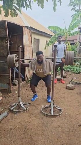 Man conducts morning barbell workout at outdoor gym in Akwanga