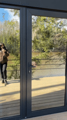 Woman takes selfie near glass door in Mishkino