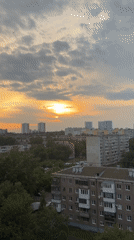 Dramatic golden sunset breaks through clouds over urban cityscape