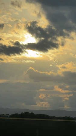 Sunset captured through clouds over Bulgarian countryside field