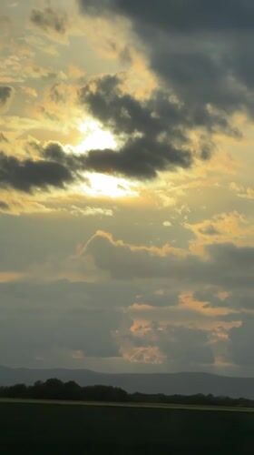 Sunset captured through clouds over Bulgarian countryside field