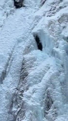 Ice climbers scale frozen waterfall in Myrland, Norway