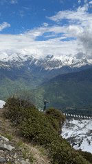 Man gestures from cliff platform near suspension bridge in Russia