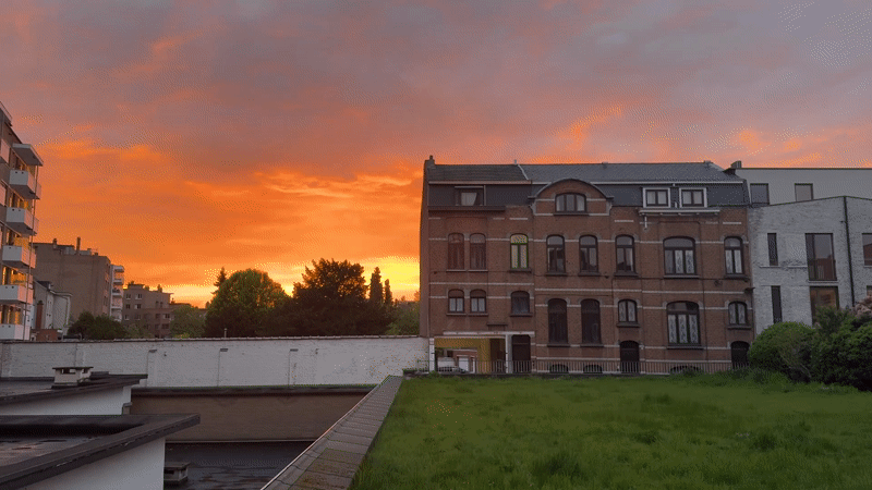 Dramatic sunset illuminates Mechelen skyline with orange hues