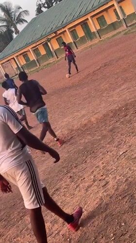 Young men play informal football on dirt field in Nigeria