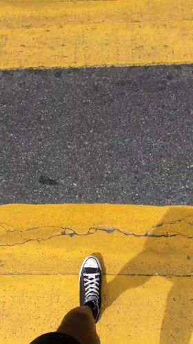 Pedestrian crosses yellow crosswalk near In-N-Out in Los Angeles