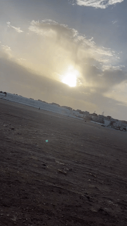 Overcast evening scene captured over dirt field in Safi