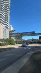 Blue train crosses elevated tracks over New Westminster street