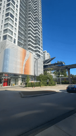Blue train crosses elevated tracks over New Westminster street