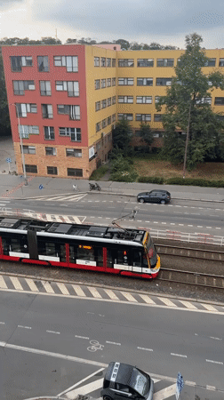Prague street traffic: trams, cars, and scooters on a gray afternoon