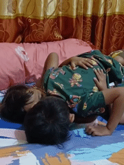 Two kids goofing around on a bed in Blang Cut