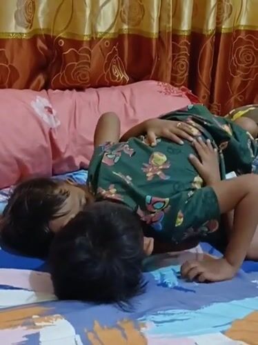 Two kids goofing around on a bed in Blang Cut
